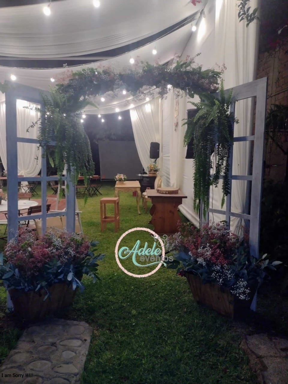 Arco decorado con exuberantes flores y vegetación, colocado como entrada para una boda al aire libre en Cieneguilla.