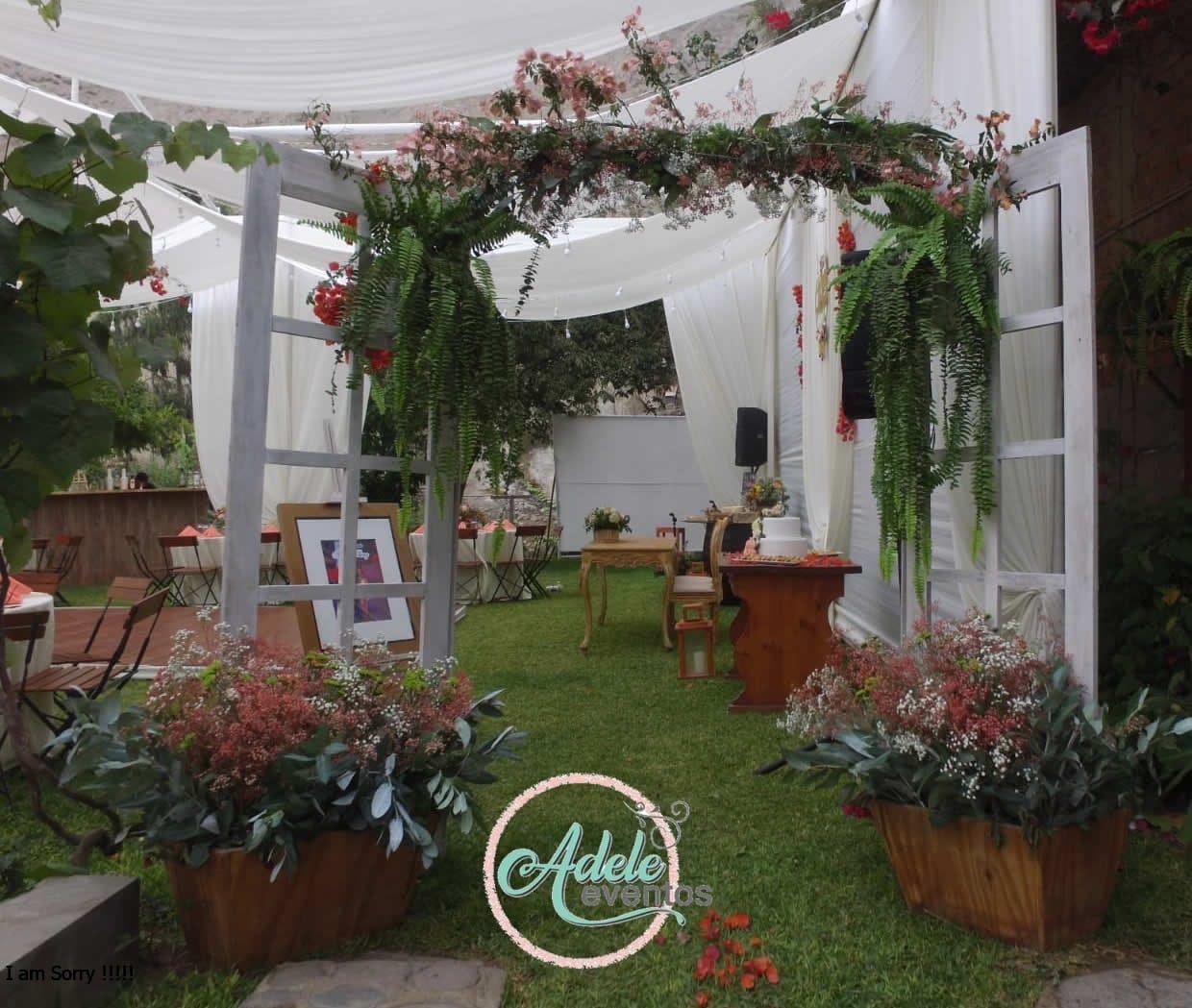 Elegante arco de flores y vegetación decorando la entrada a una boda en Cieneguilla, con una mesa decorada y sillas para los invitados alrededor.