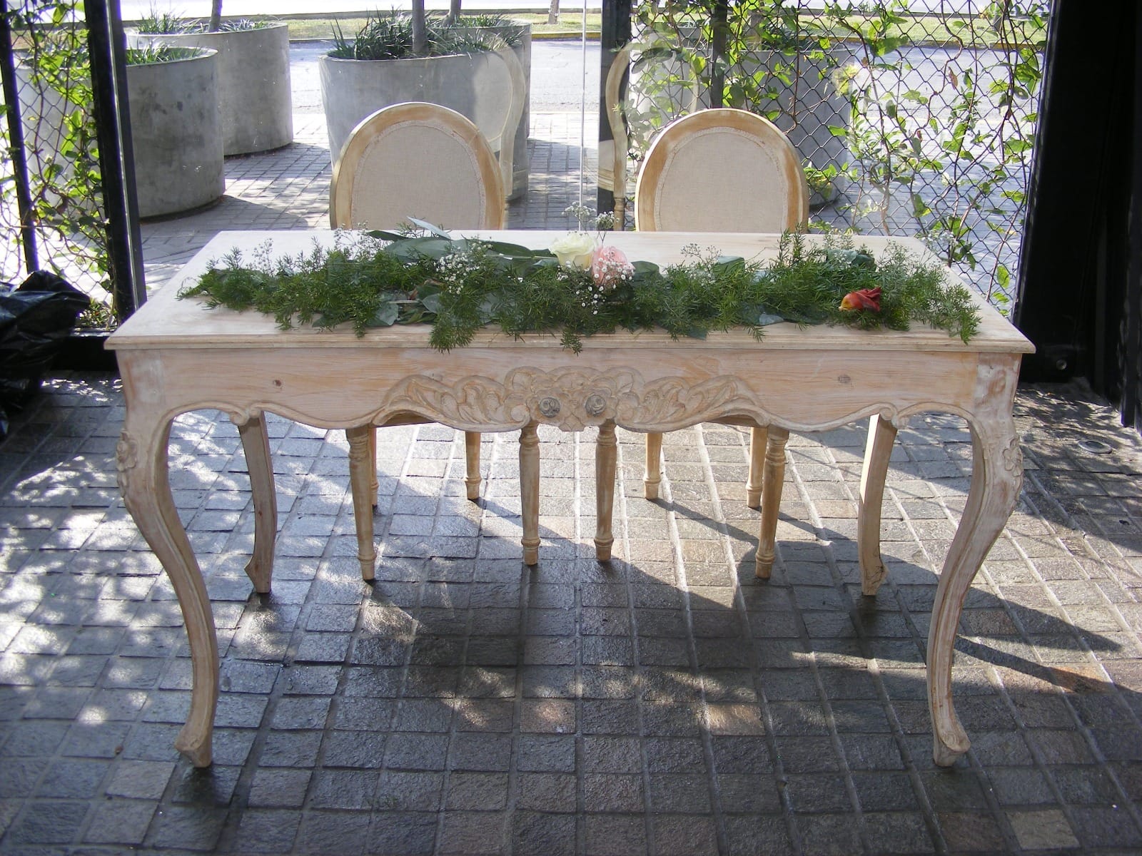 Arreglo floral en mesa rústica de madera en evento al aire libre en Cieneguilla
