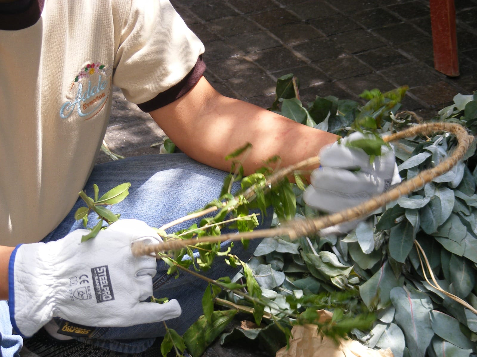 Persona arreglando una planta con guantes protectores en evento en Cieneguilla