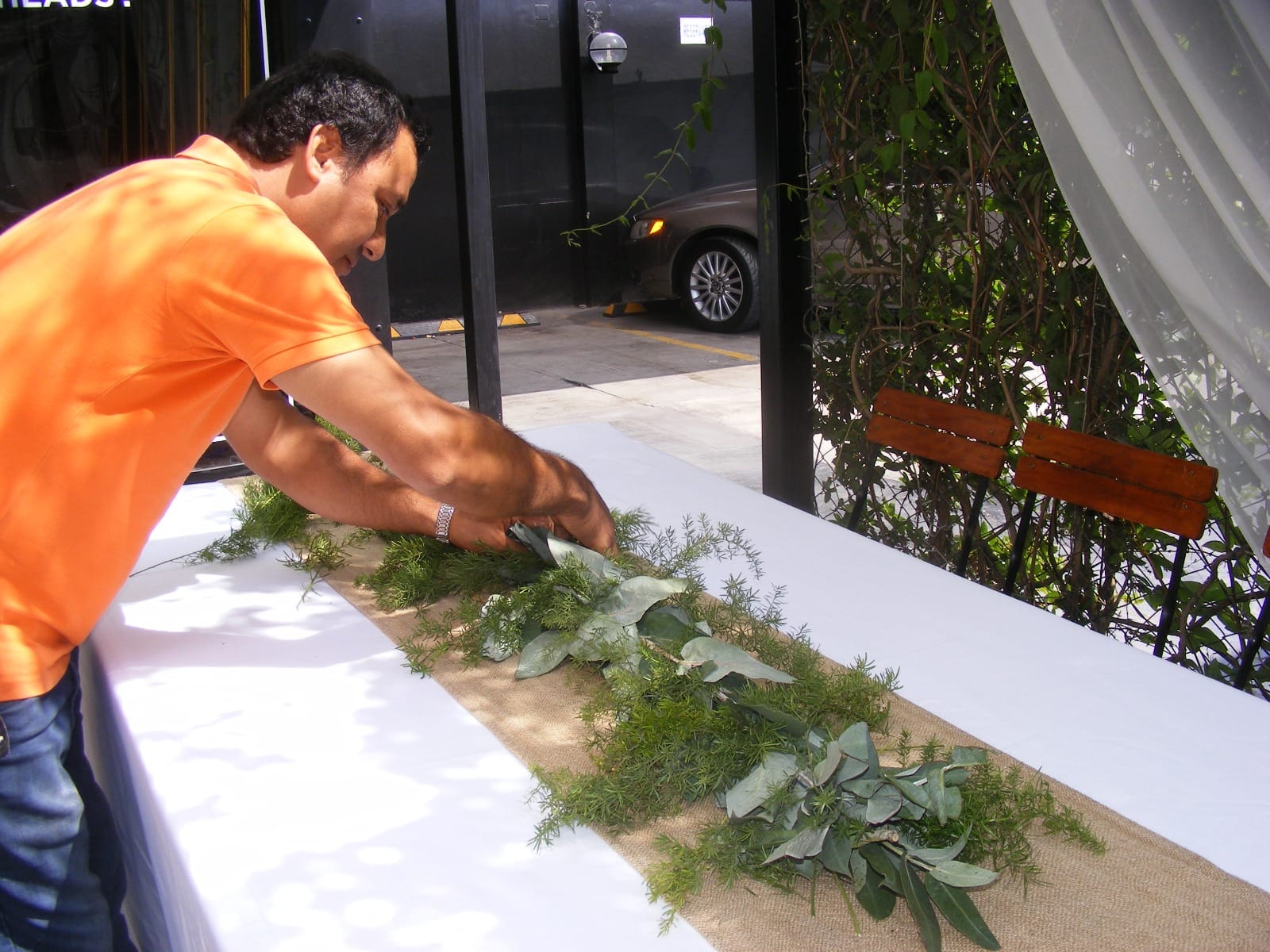 Persona arreglando vegetación en una mesa para evento en Cieneguilla
