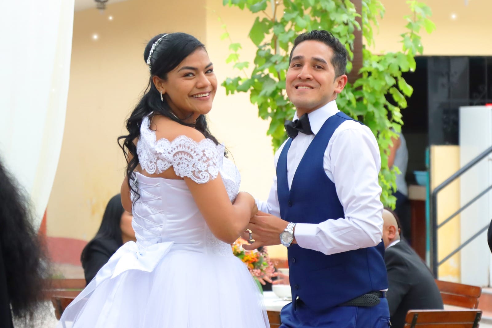 Pareja de novios bailando durante su boda en Cieneguilla, con la novia en un vestido blanco y el novio en un traje azul.