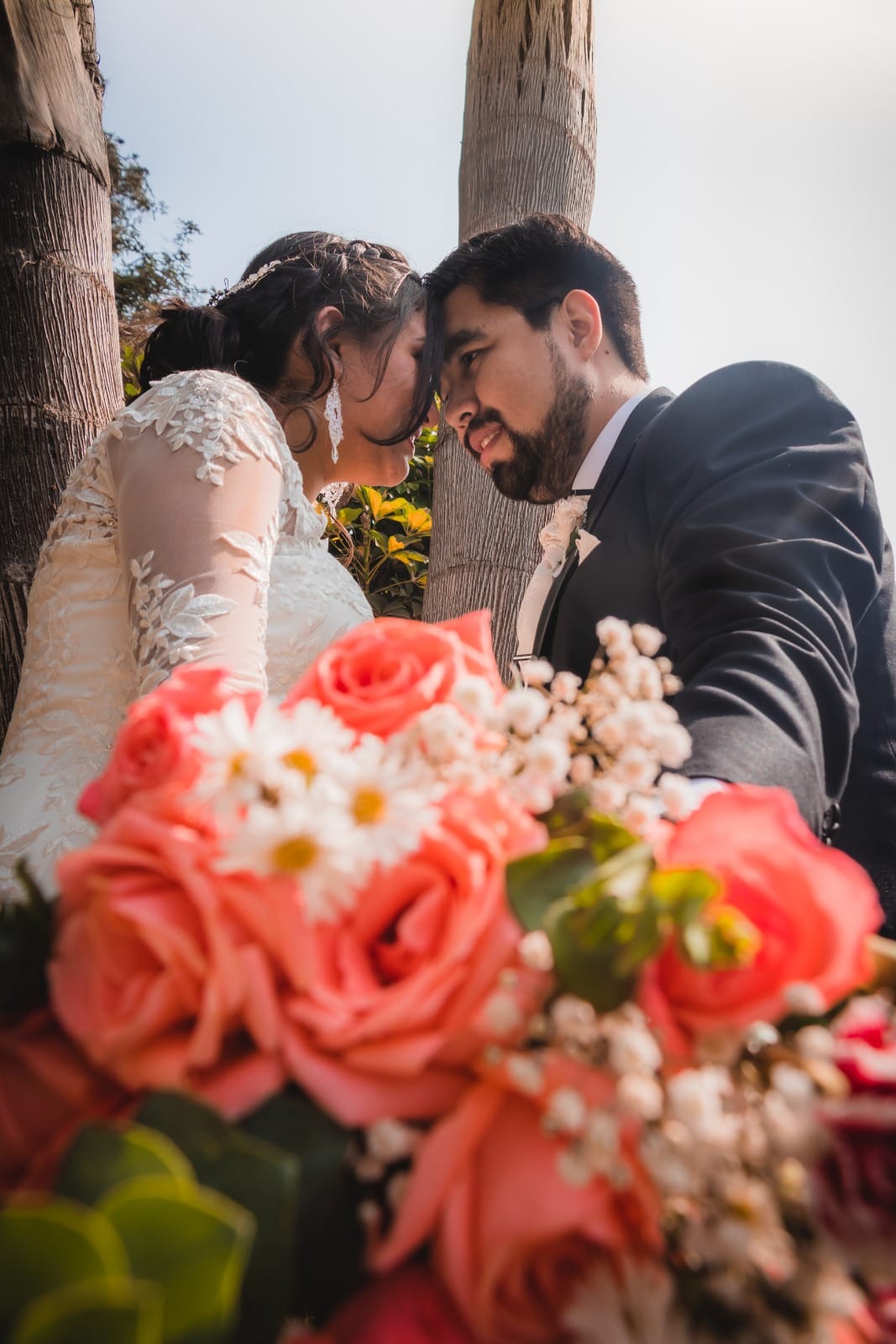 Pareja de novios abrazándose con un ramo de flores en Cieneguilla