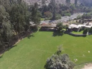 Vista aérea de una área verde con casas y vehículos para alquiler de eventos en Cieneguilla