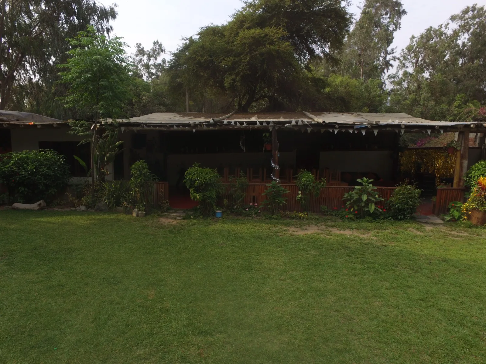 Configuración exterior con césped, carpas blancas, sillas y mesas para un evento en una casa en alquiler en Cieneguilla.