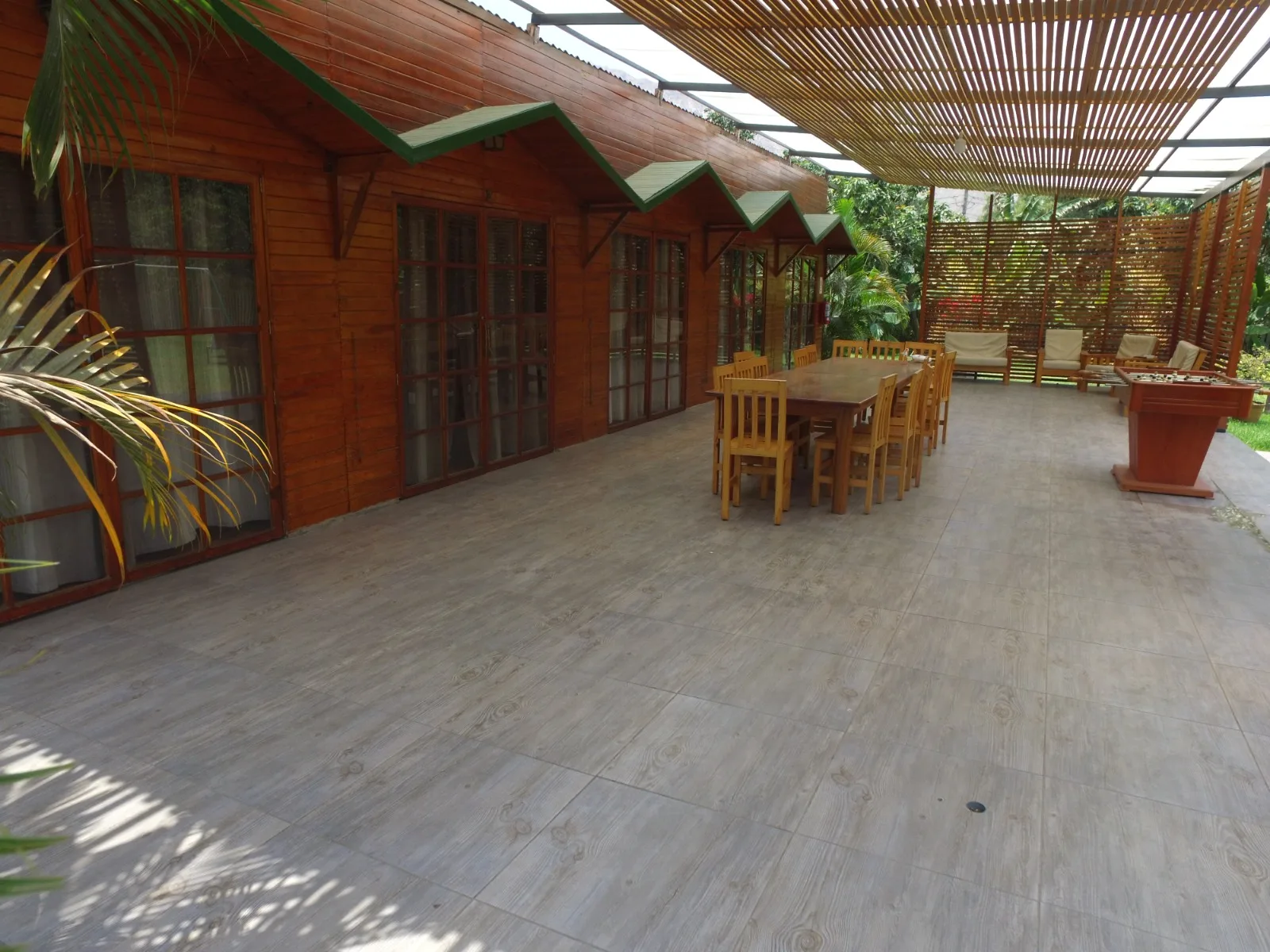 Patio exterior con techo de madera y mesa de madera en una casa en alquiler en Cieneguilla.