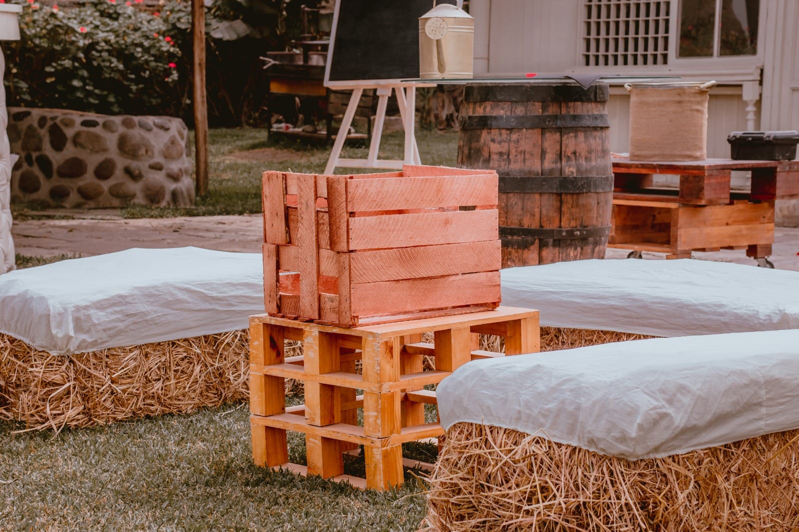 Configuración rústica al aire libre con pacas de heno, barril de madera, y caja de madera en un jardín en Cieneguilla