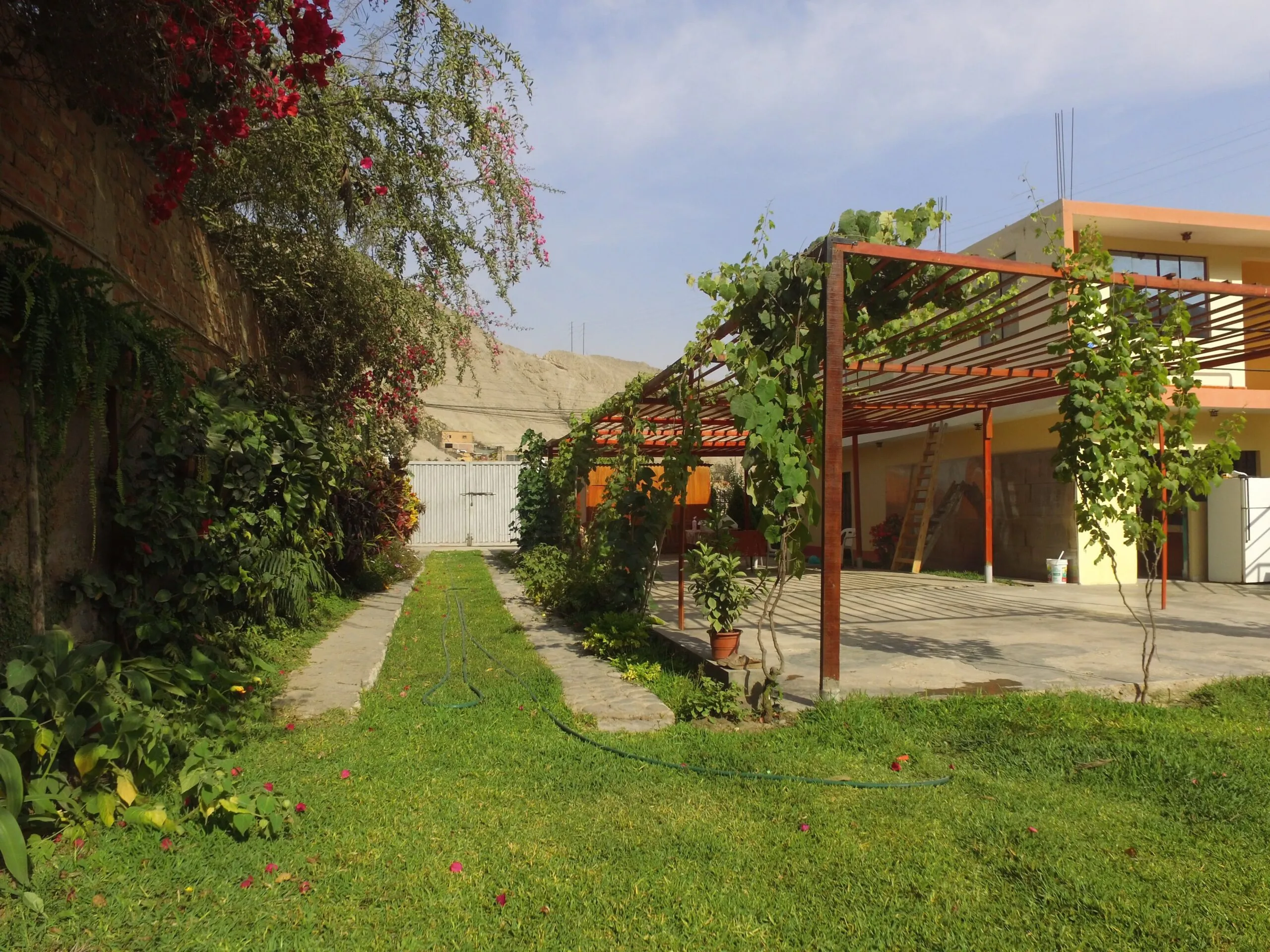 Jardín con caminos de piedra y follaje verde para alquiler de eventos en Cieneguilla