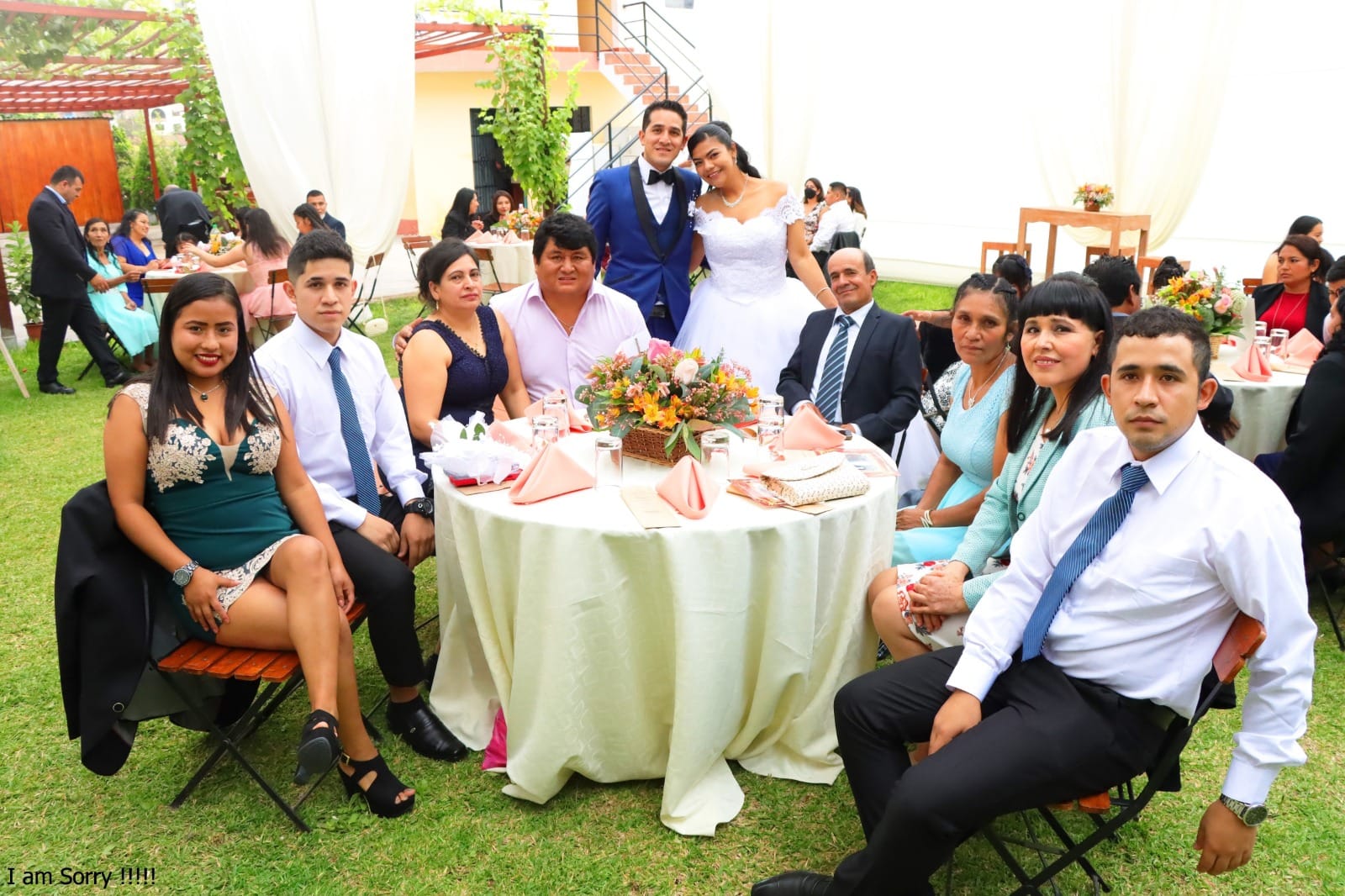 Pareja de recién casados posando junto a su familia durante la recepción de boda al aire libre en Cieneguilla.