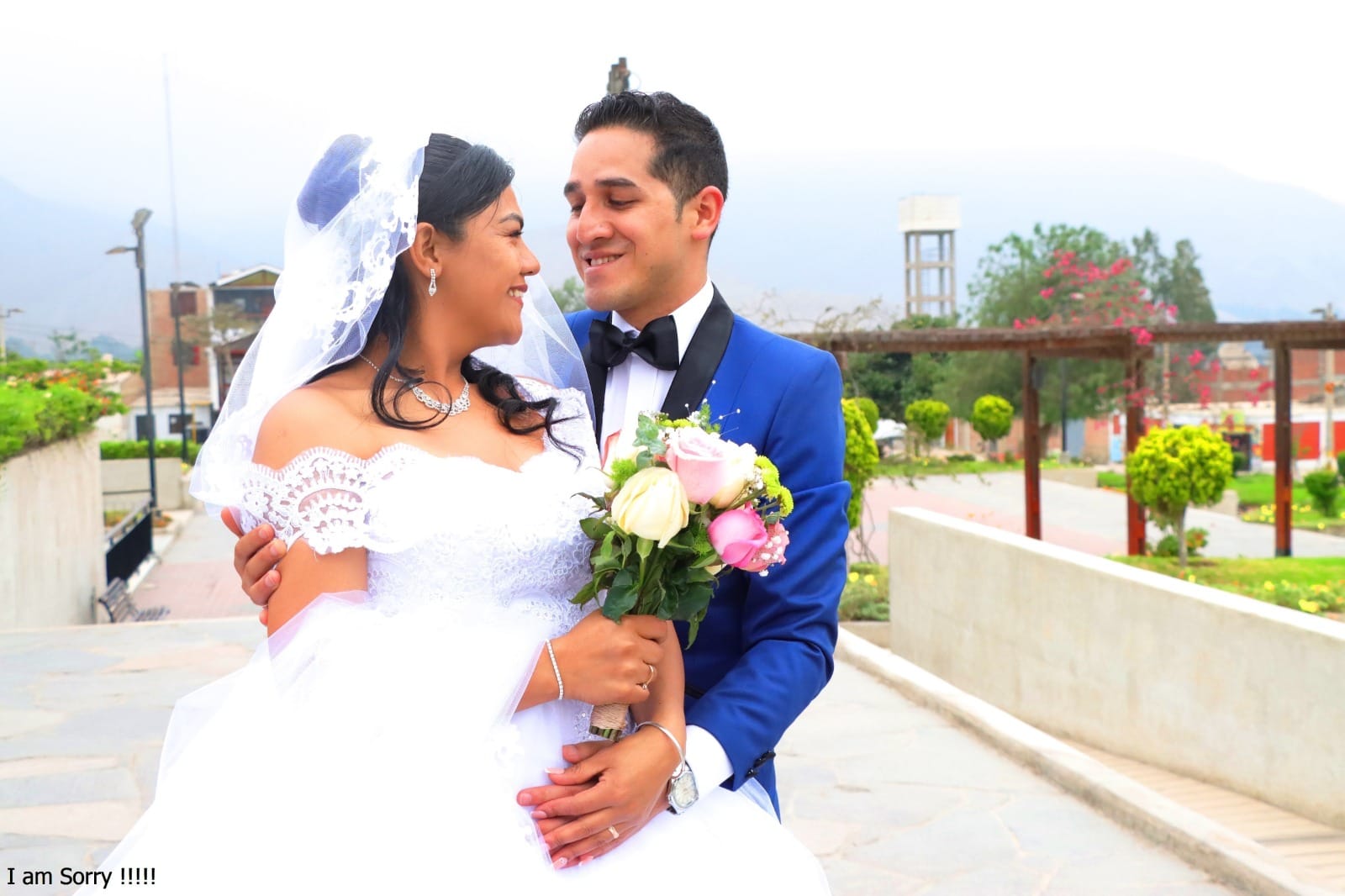 Pareja de novios al aire libre en boda en Cieneguilla, con la novia en vestido blanco y el novio en traje azul.
