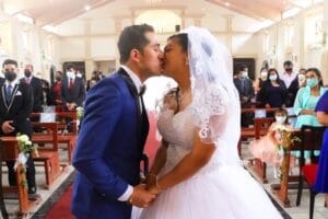 "Pareja de novios dentro de una capilla en Cieneguilla durante su boda, con la novia en vestido blanco y el novio en traje azul.