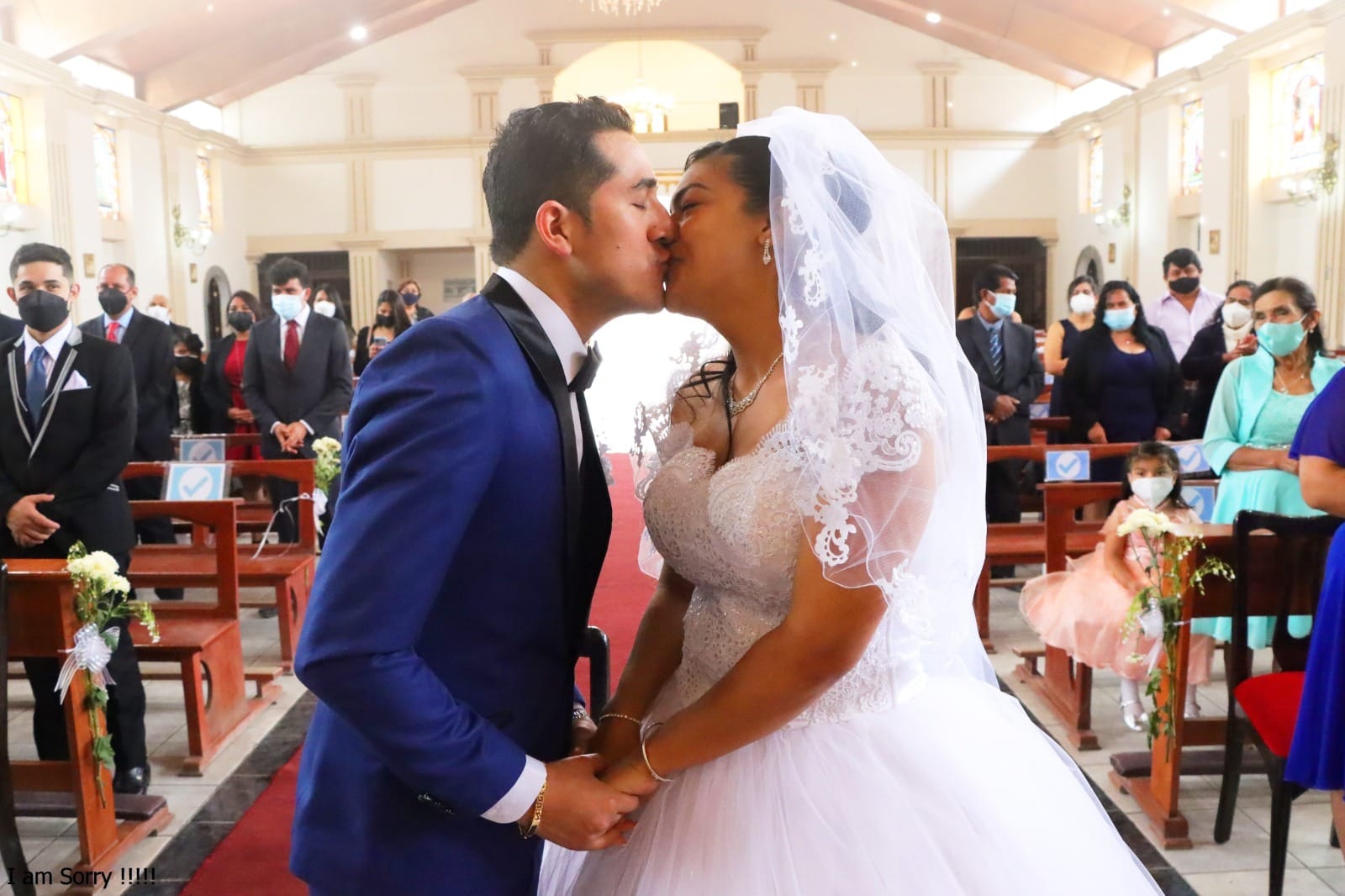 "Pareja de novios dentro de una capilla en Cieneguilla durante su boda, con la novia en vestido blanco y el novio en traje azul.