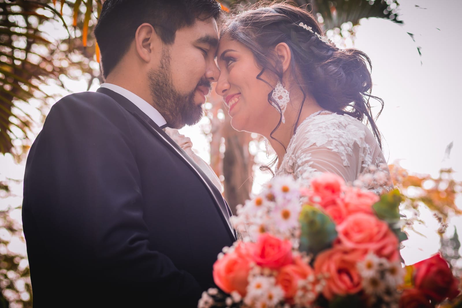 Pareja vestida formalmente, la persona a la izquierda con un traje oscuro y la persona a la derecha con un vestido de encaje blanco, en Cieneguilla