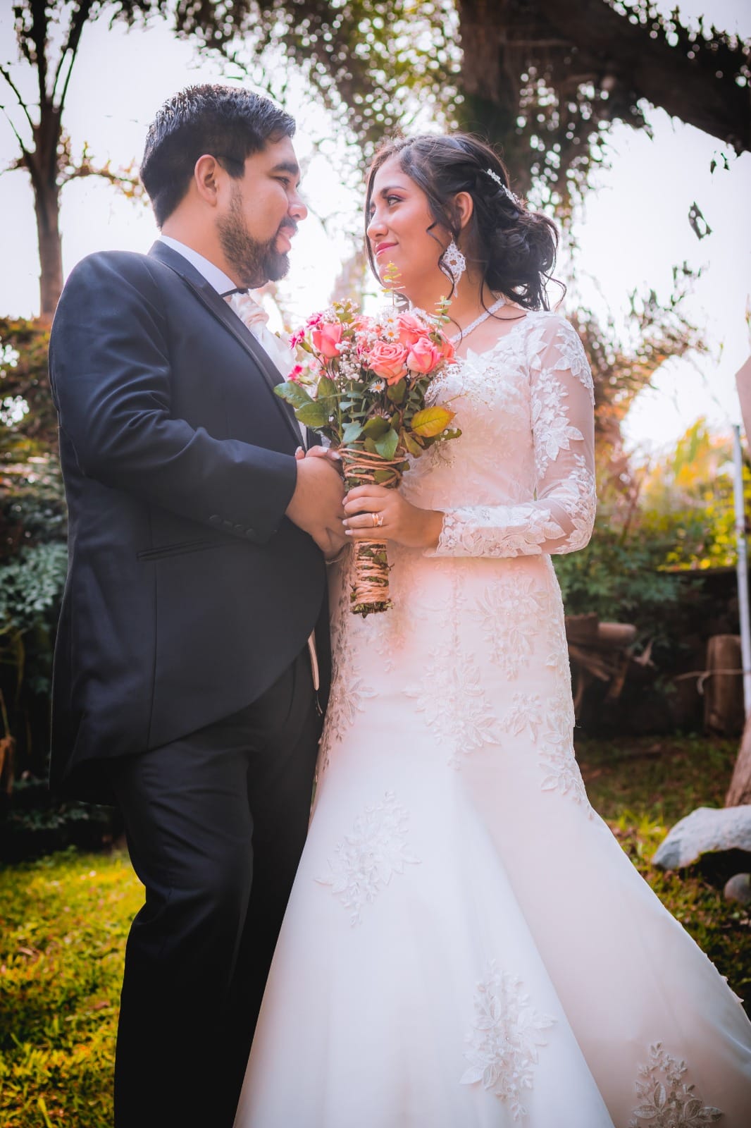 Pareja vestida formalmente, la persona a la izquierda con traje oscuro y la persona a la derecha con vestido de encaje blanco, en Cieneguilla