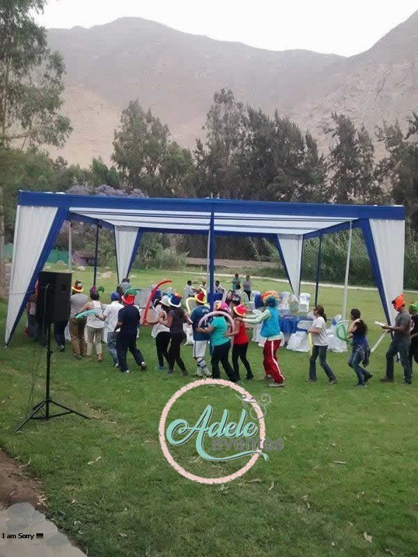 Instalación de toldo azul y blanco con equipo de sonido para fiesta de integración empresarial al aire libre en Cieneguilla por Adele Eventos.
