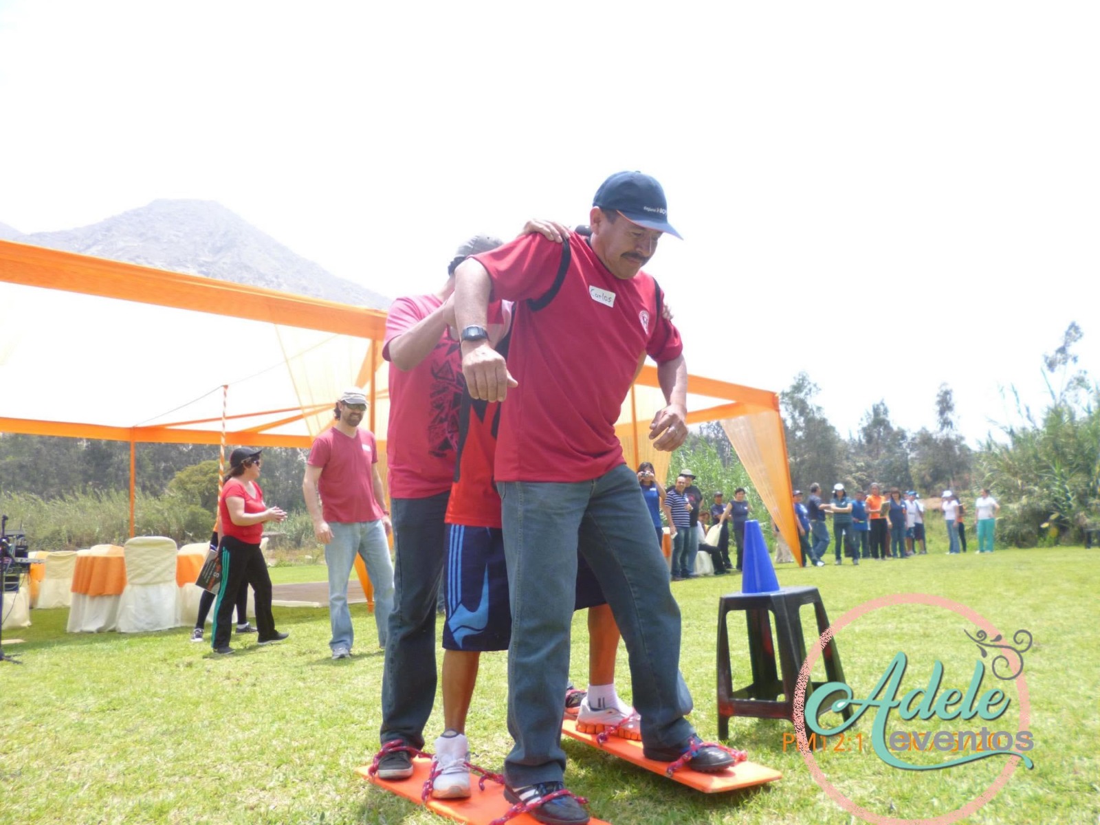 Equipo empresarial realizando una dinámica outdoor sobre esquís en un jardín en Cieneguilla.
